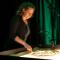 L'artiste dessine sur une table lumineuse avec du sable